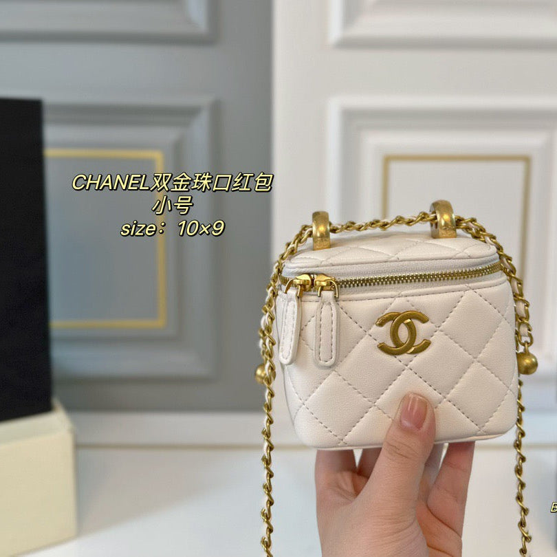 White quilted handbag with gold chain and hardware held by a hand against a neutral background