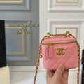 Pink Chanel handbag with gold chain held by a hand against a neutral background